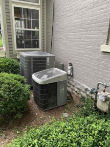 outdoor air conditioning located units behind green shrubbery